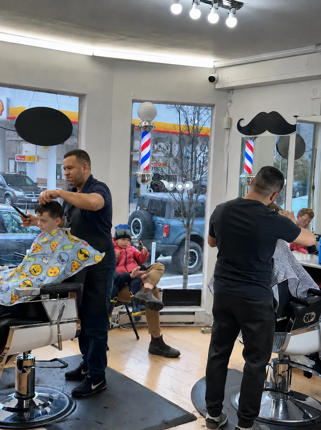 Barbers working with clients inside CHAIR 186